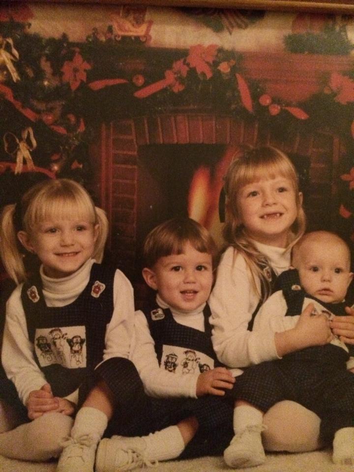 Four children in front of a fireplace
