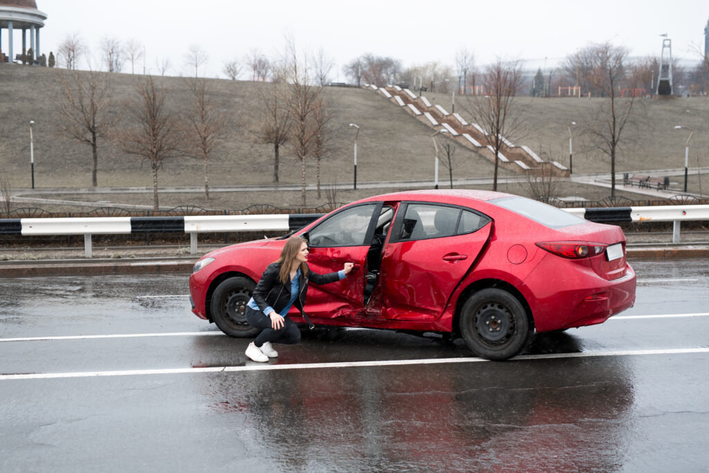 Woman examines her car after an accident.