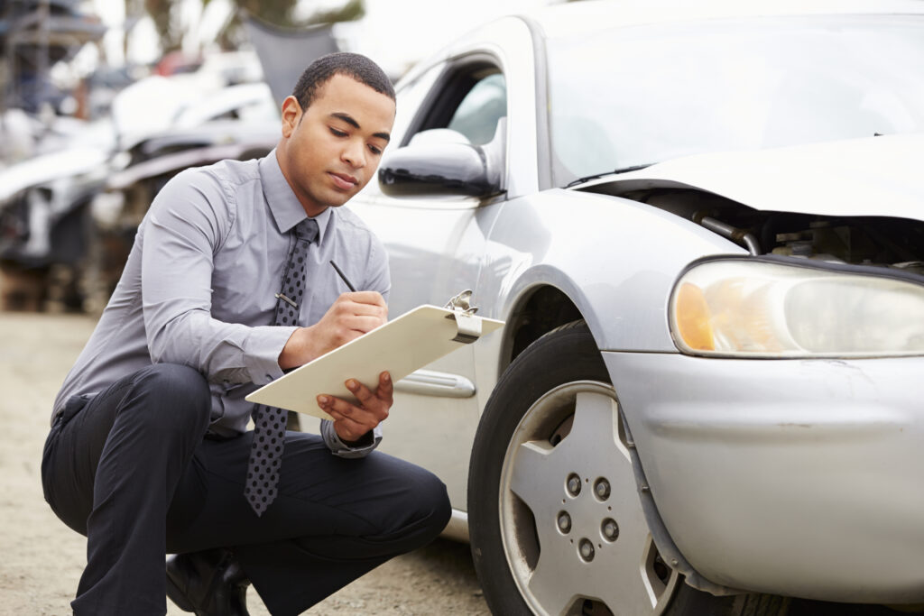 Insurance adjuster assessing damages after a car accident