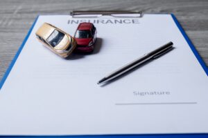 Toy cars on stack of papers concerning car insurance