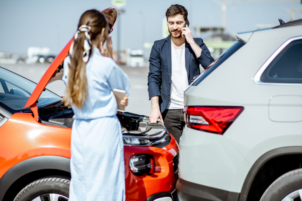 Two drivers inspecting their cars after an accident