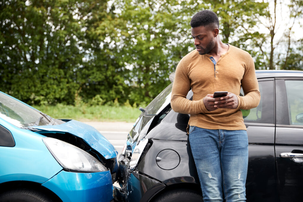 Man surveying damage to his car after a fender bender