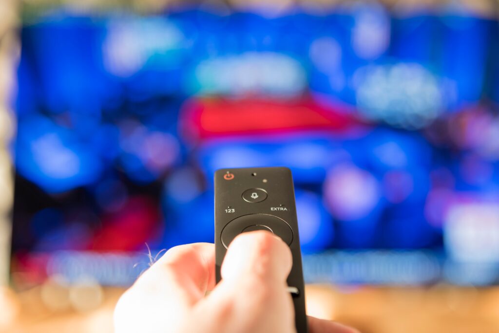 Person holding remote looking through streaming options