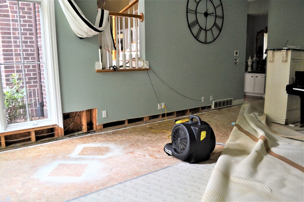 A fan dries out water damaged walls in a  home.