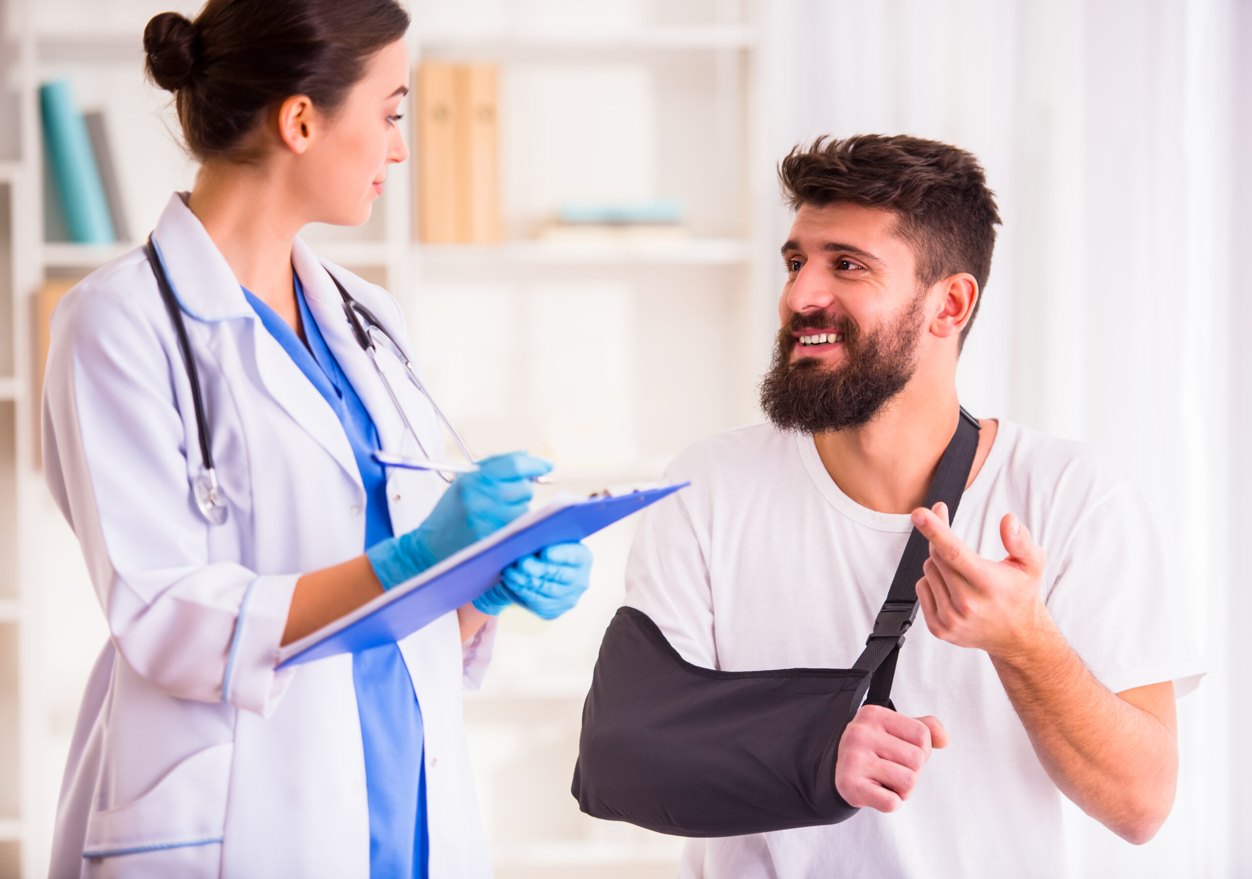 man with arm in sling speaking to doctor