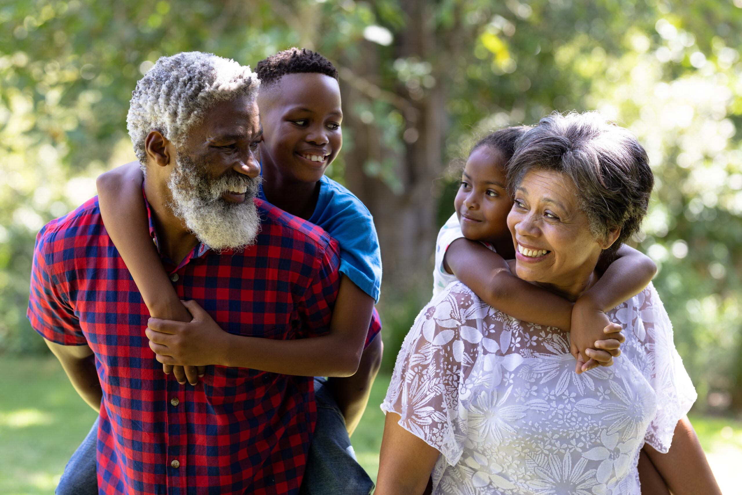African-American seniors giving piggyback rides to grandkids