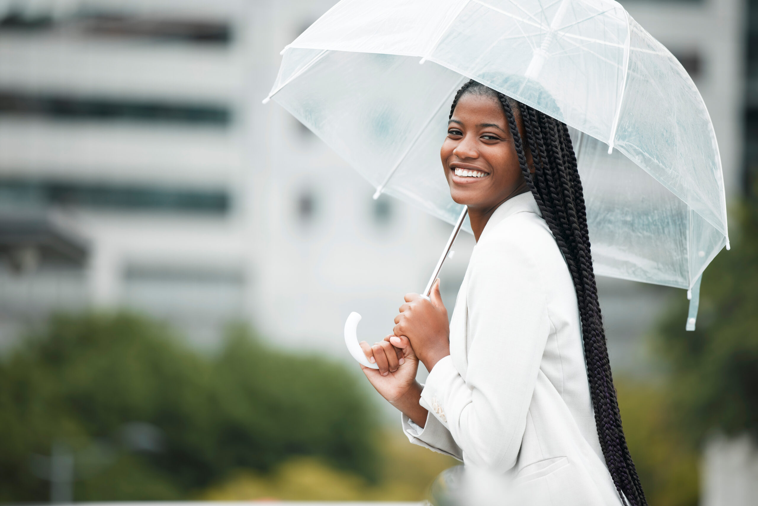 Fashion, umbrella and city with a walking black woman in the street during a cold rain or wet winte.