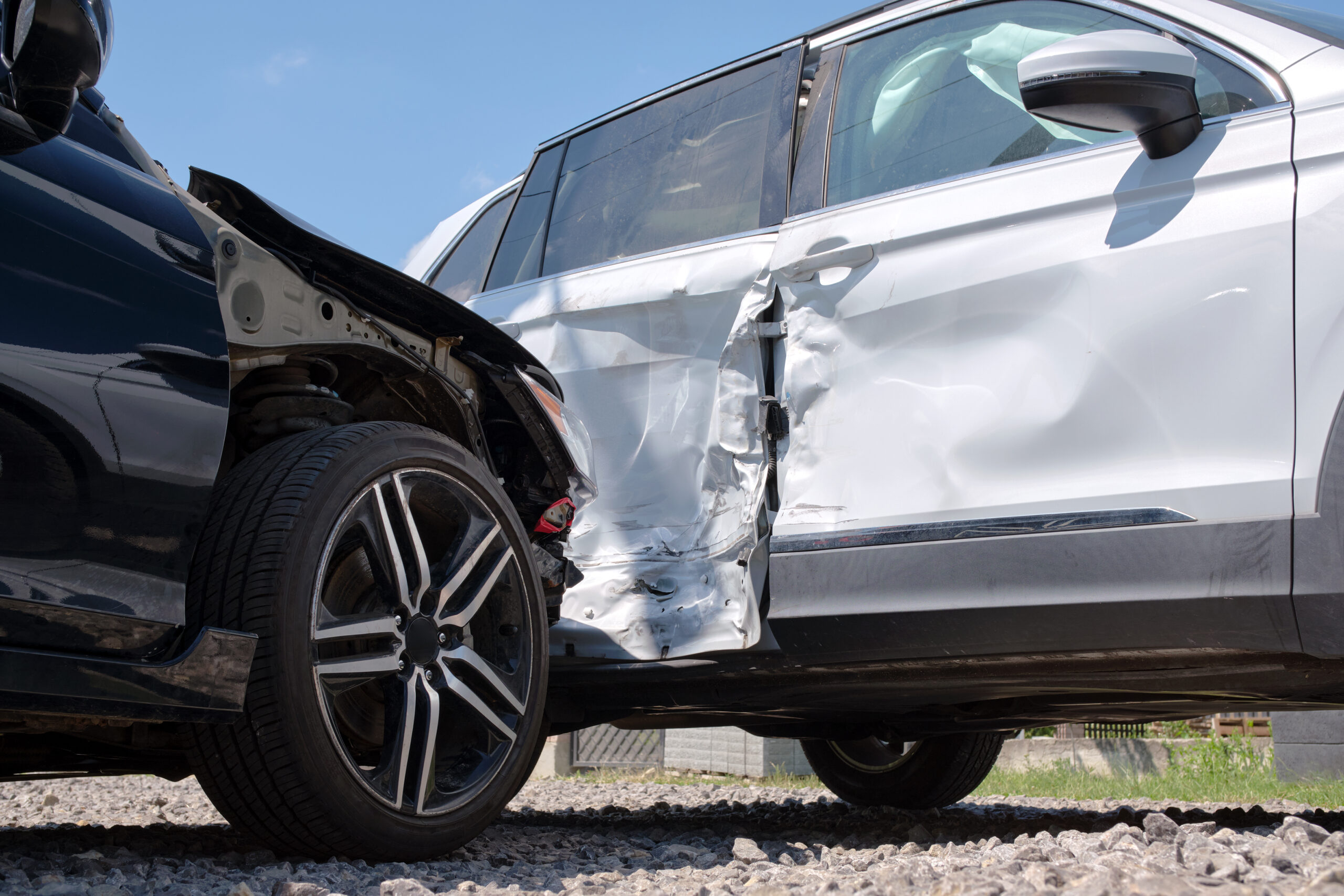 Damaged in heavy car accident vehicles after collision on city street crash site. Road safety and insurance concept.