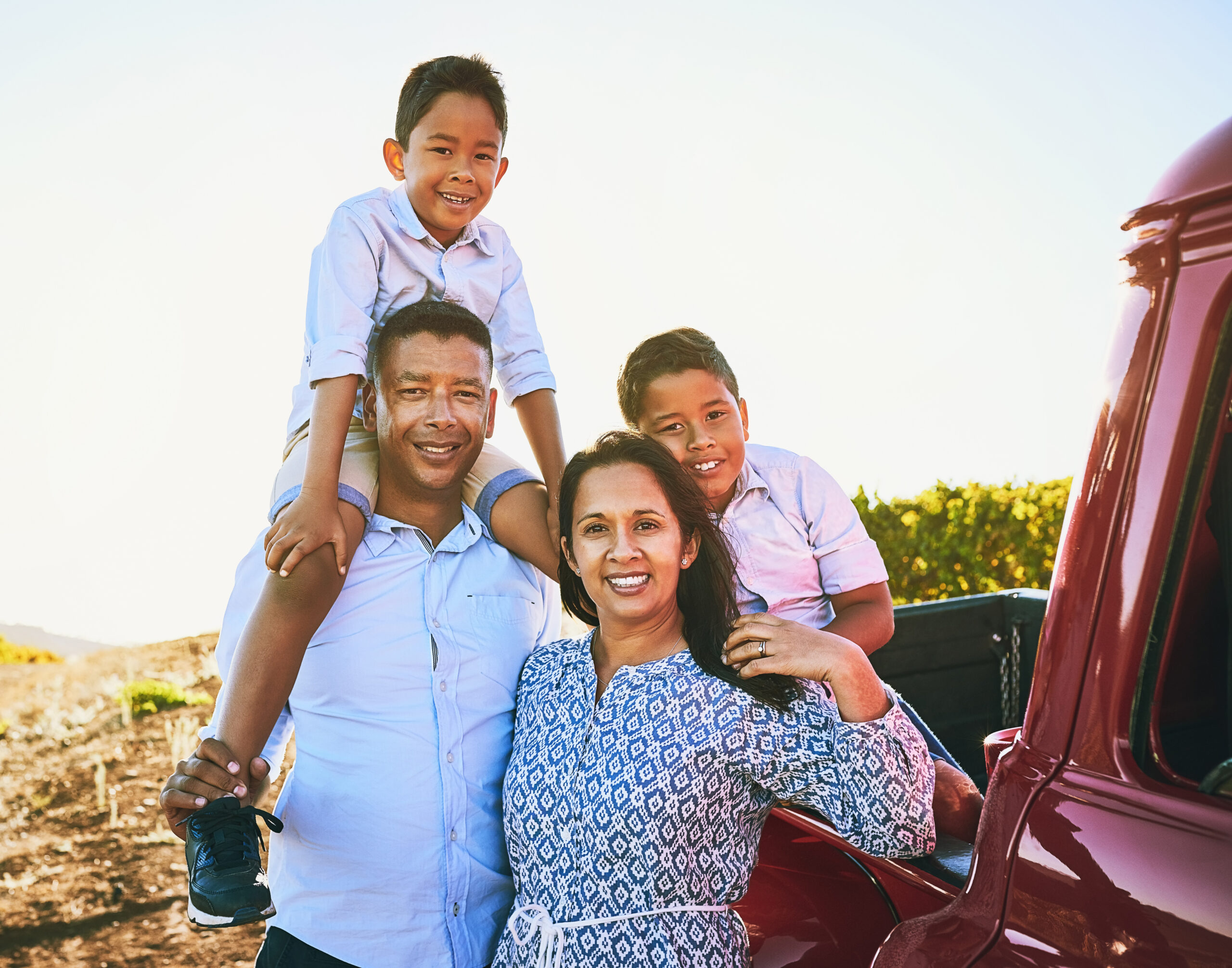Happy family posing next to pickup truck