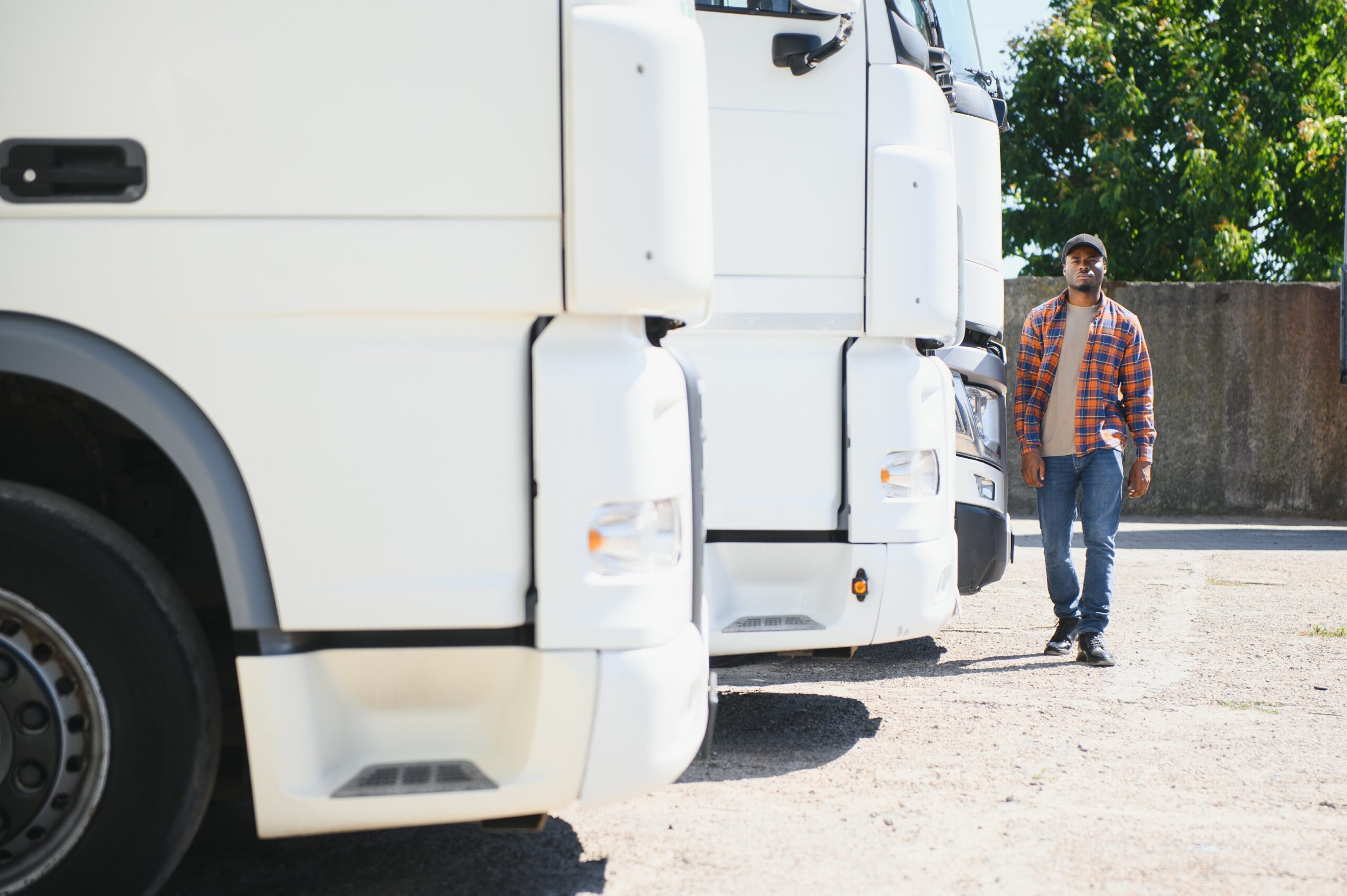 Man walking past commercial semi truck fleet
