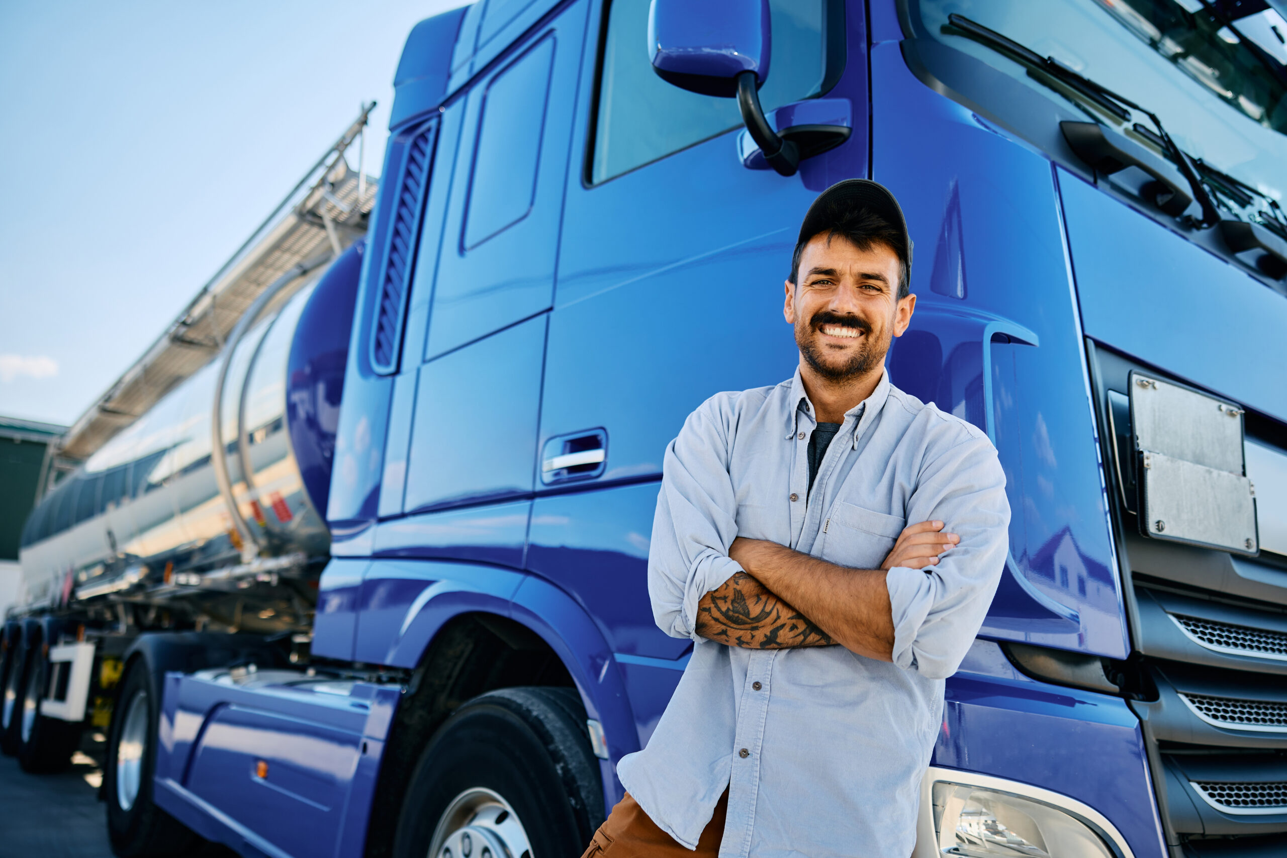 truck driver leaning against semi