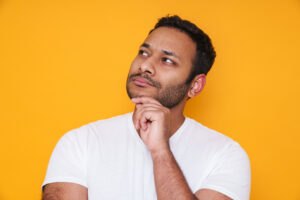 Man thinking against bright yellow background